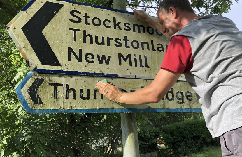 Cllr Richard Smith cleaning road signs in Kirkburton